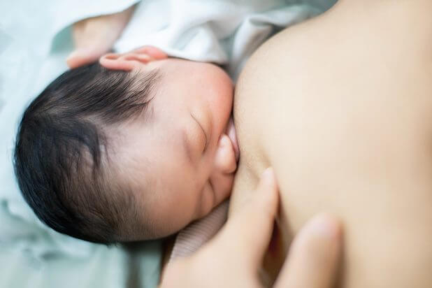 Closeup portrait of Asian mother breastfeeding her newborn baby with breast milk. Drinking milk for good health. Concept about the growth of children.